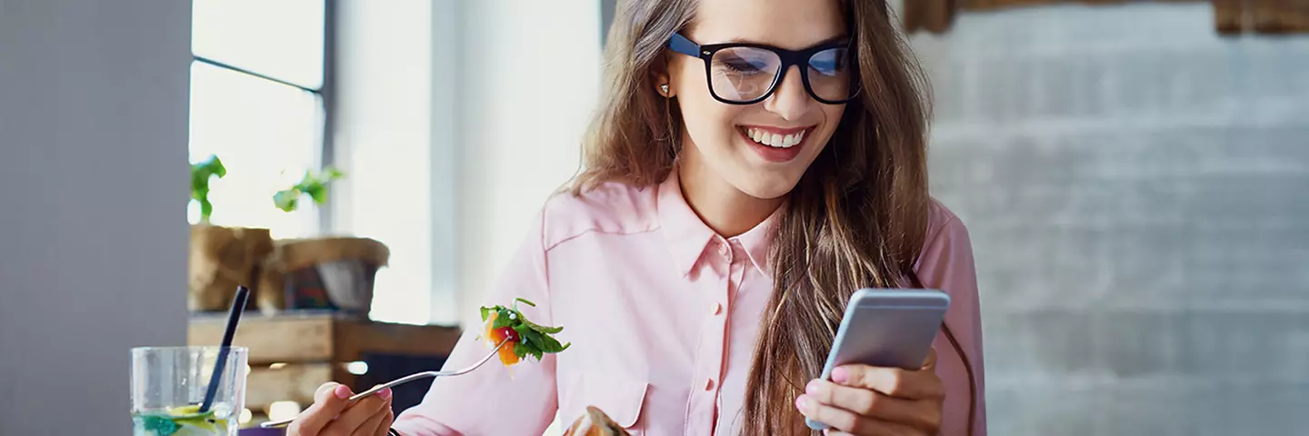 Lächelnde Frau schaut auf ihr Handy