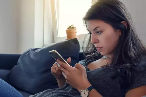 Frau auf dem Sofa mit Handy