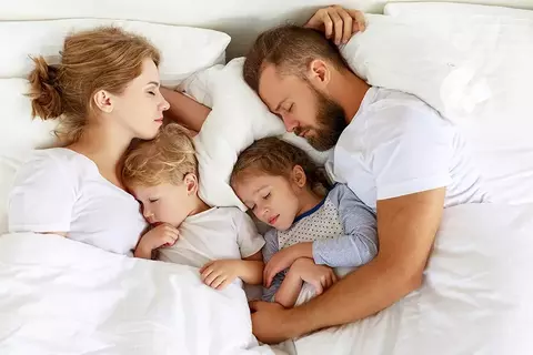 Schlafende Familie im Bett