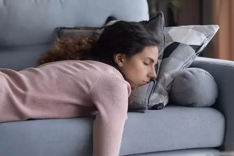 Frau liegend auf dem Bauch auf dem Sofa