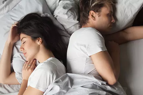 Paar liegend Rücken an Rücken im Bett