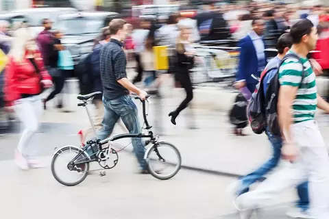 Mann mit Klapprad in der Menge