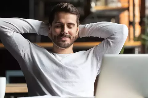 Mann entspannt vor einem Notebook